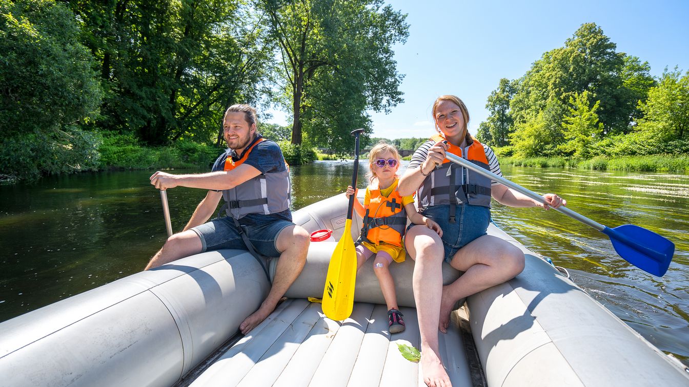 Eine Familie paddelt im Schlauchboot über die Mulde.