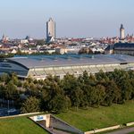 QUARTERBACK Immobilien ARENA: Außenansicht der Eventlocation mit Hintergrund der Stadt für Tagung & Konferenz Leipzig Convention