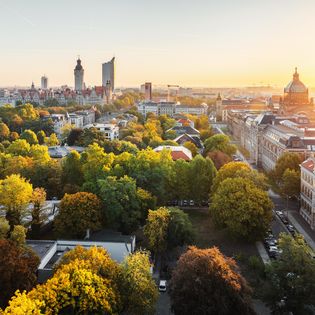 Skyline von Leipzigs Innenstadt - Reise nach Leipzig Skyline von Leipzigs Innenstadt bei Sonnenaufgang im Spätsommer, am Horizont sieht man wichtige Sehenswürdigkeiten aus Leipzig wie das City-Hochhaus, das Wintergartenhochhaus und das Bundesverwaltungsgericht